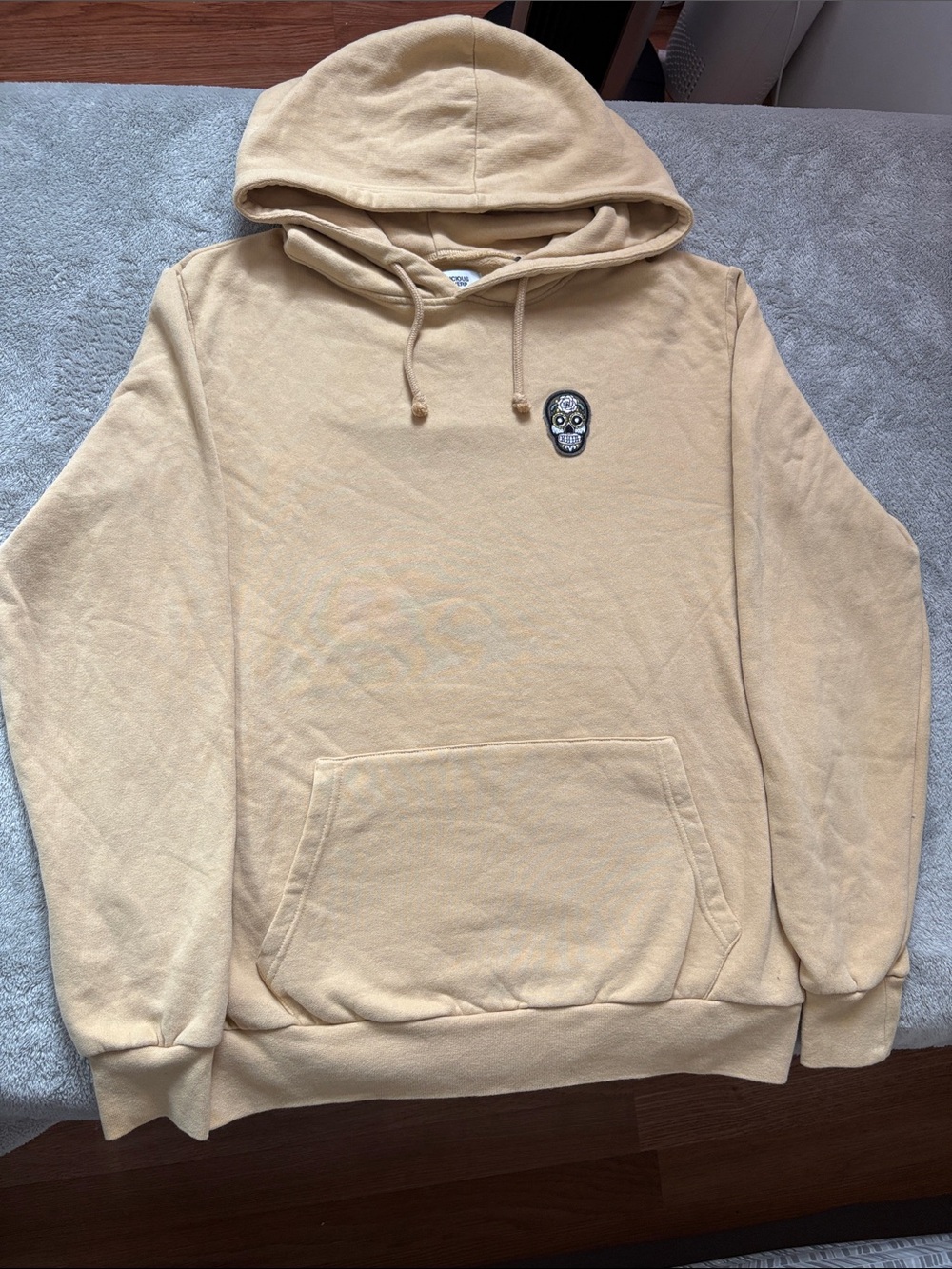 SUSPICIOUS ANTWERP Men's Cream Pullover Hoodie with Embroidered Skull Patch